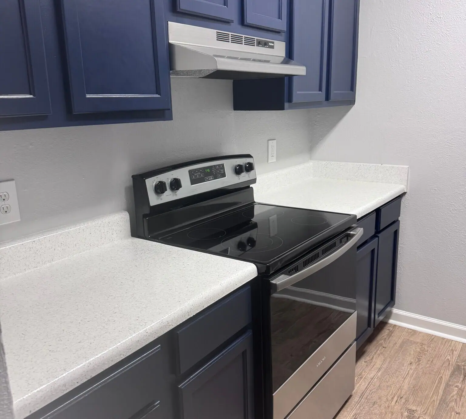 Blue cabinetry and stainless steel appliances in a Cypress Cove apartment kitchen